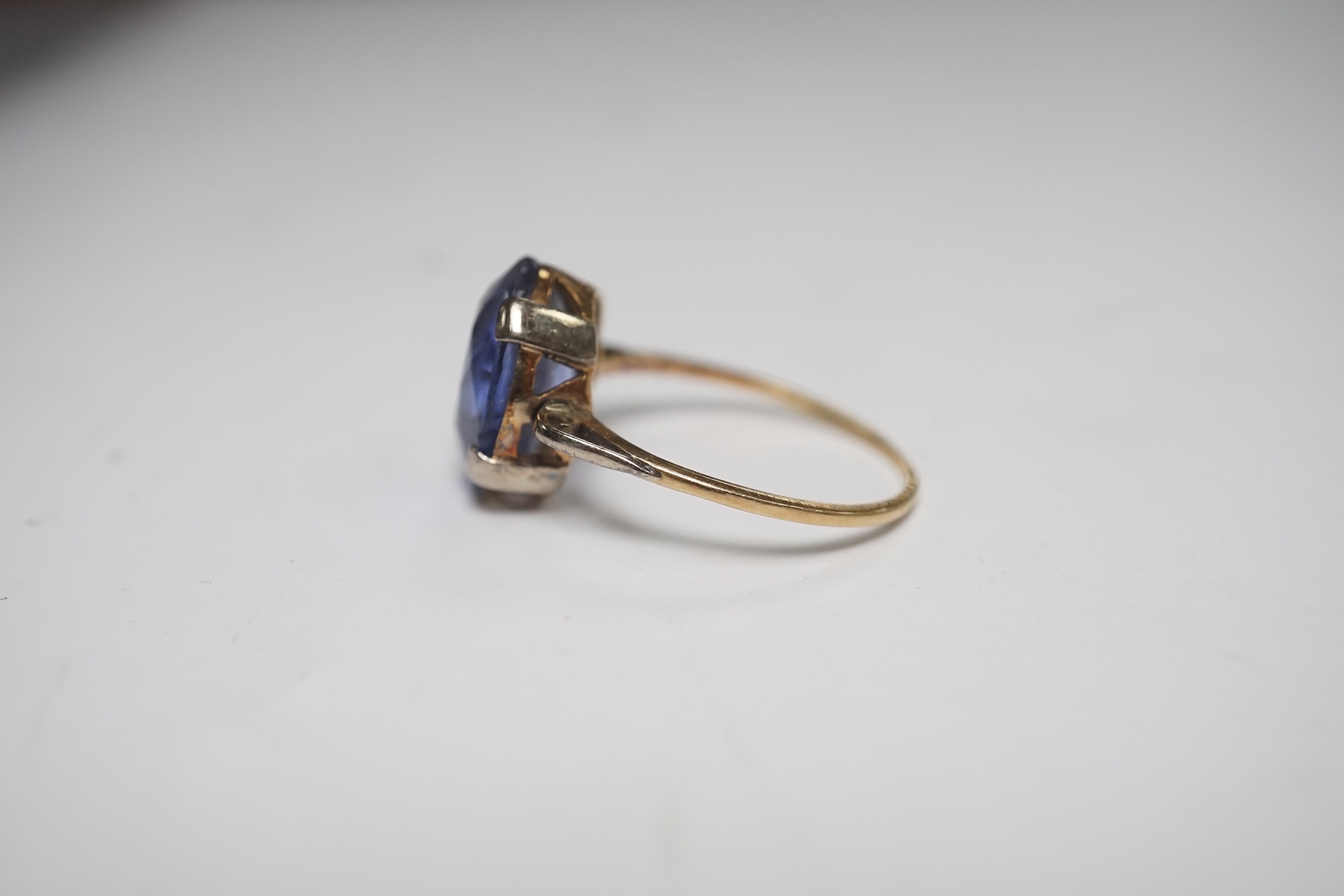 A yellow metal and single stone oval cut synthetic? sapphire set ring, size N, gross weight 2.8 grams. Condition - poor to fair